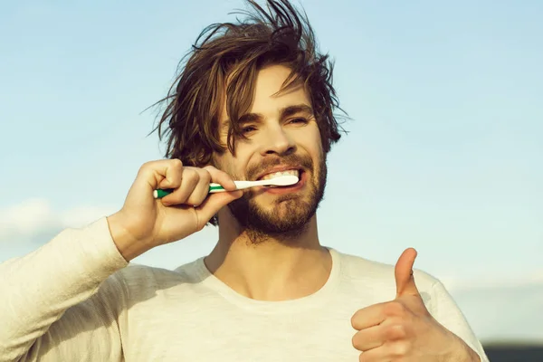 Pollice su di uomo felice lavarsi i denti con dentifricio, metrosessuale — Foto Stock