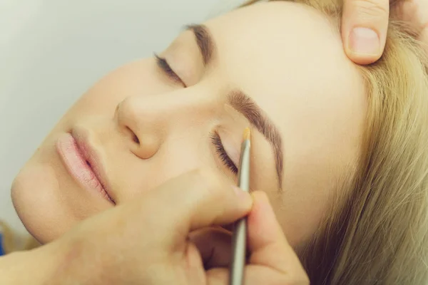 Chica con los ojos cerrados conseguir maquillaje en los párpados —  Fotos de Stock