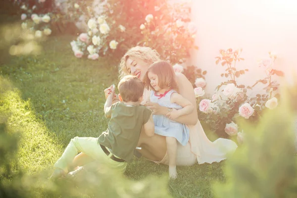 Mutter spielt mit Tochter und Sohn im Sommergarten — Stockfoto