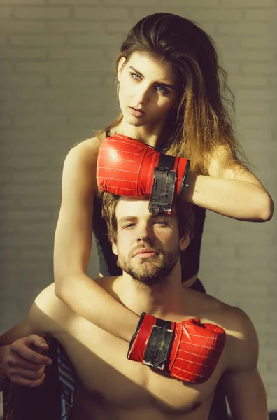 Ładna dziewczyna w czerwone rękawice bokserskie, przytulanie przystojny mężczyzna — Zdjęcie stockowe