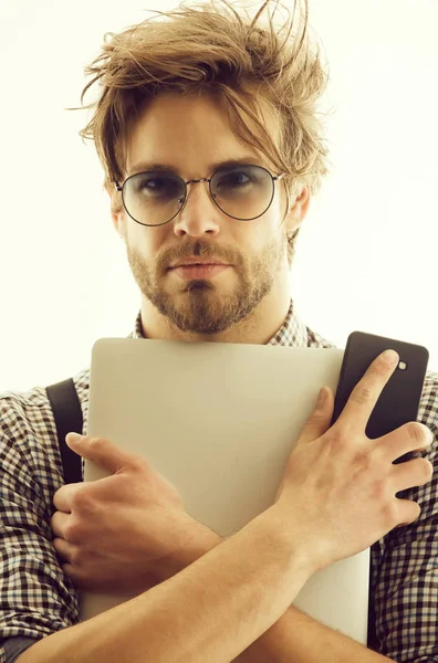 Hombre guapo en gafas con computadora portátil y teléfono inteligente —  Fotos de Stock