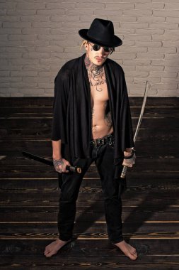 Savaşçı siyah şapka ve dövmeli gövde gösterilen açık giyim