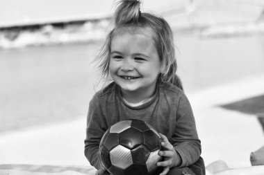 Topu tutan uzun sarı saçlı küçük gülümseyen çocuk çocuk