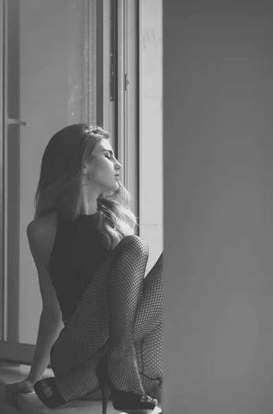 Chica bastante sexy sentado con piernas en el alféizar de la ventana — Foto de Stock