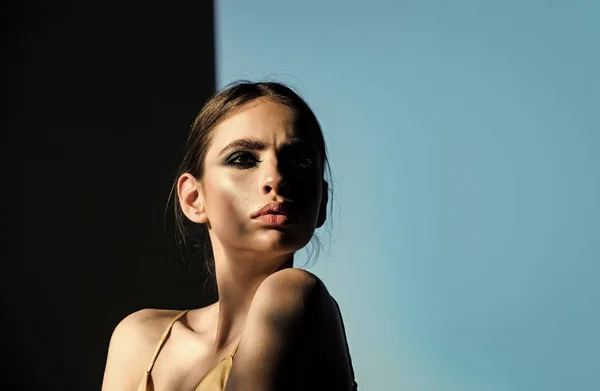 Vrouw met oogschaduw make-up op zwarte en blauwe achtergrond — Stockfoto