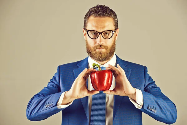 Людина в окулярах або бізнесмен тримає червоний овоч, перець — стокове фото