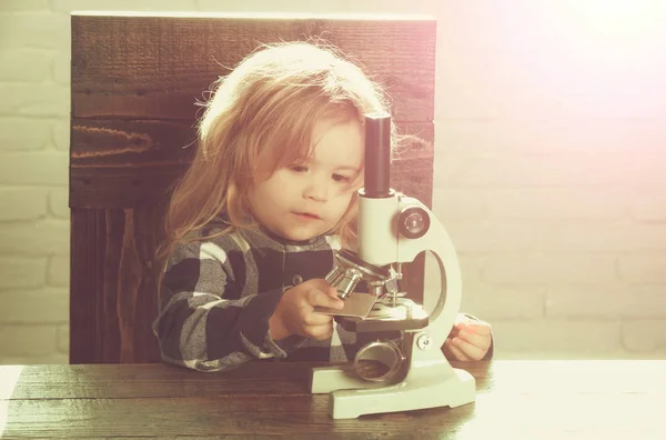 Estudante menino com estudo microscópico no local de trabalho educacional — Fotografia de Stock