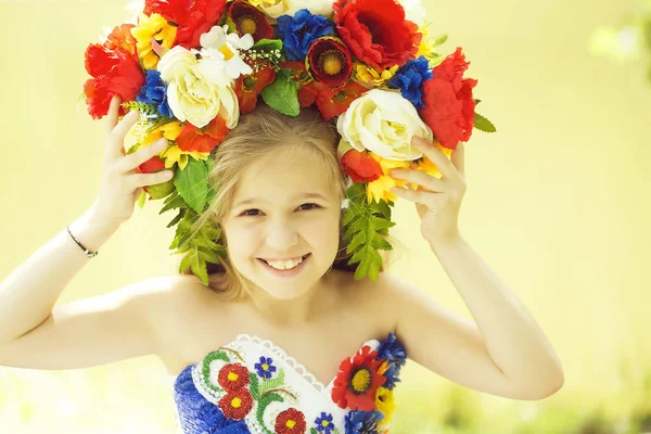 Маленька дівчинка в кольоровій сукні і квітковому національному вінку — стокове фото