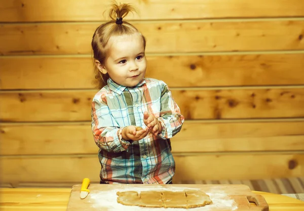 Criança bonito na camisa quadriculada cozinhar com massa e farinha — Fotografia de Stock