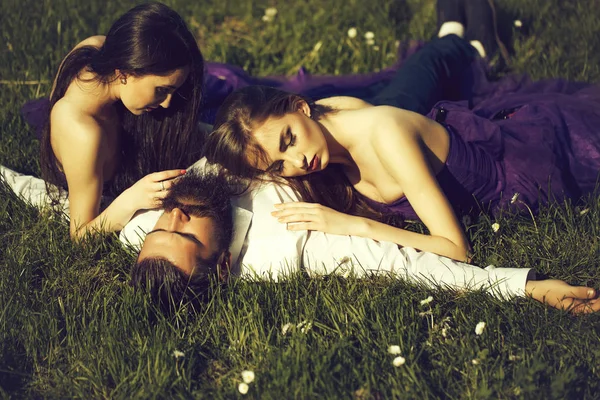 Skäggig man och två kvinnor på gräs — Stockfoto