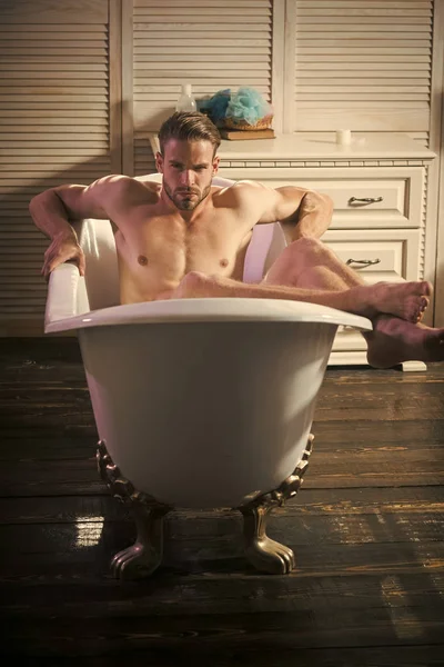 Сексуальный мужчина с обнаженным телом сидит в ванной комнате — стоковое фото