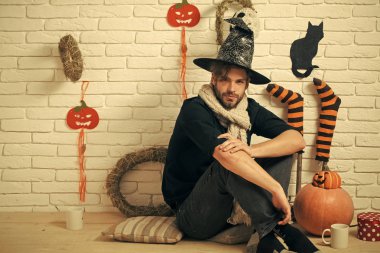 Hediye kutusu ve bardak katta oturan Cadılar Bayramı adam.