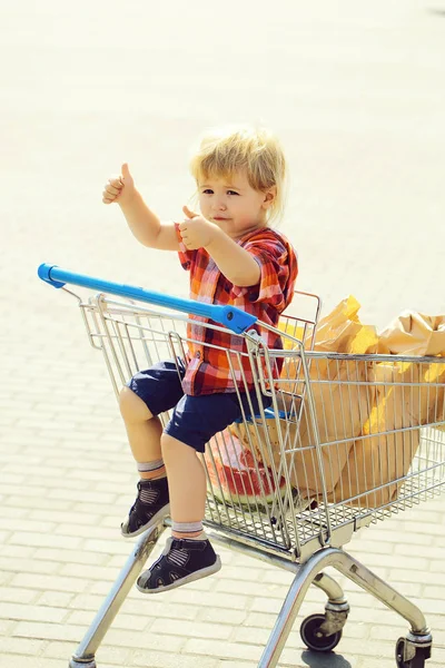 Cute boy in shopping trolley — Stock Photo, Image