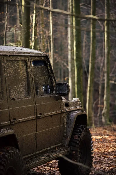 Sucio coche offroad con bosque de otoño en el fondo — Foto de Stock