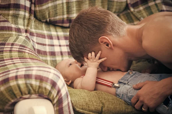 Pai brincar com o bebê filho no sofá — Fotografia de Stock