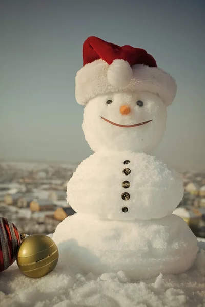 Snögubbe i röda jultomten hatt. — Stockfoto