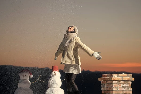 Santa claus girl with snowman at chimney.