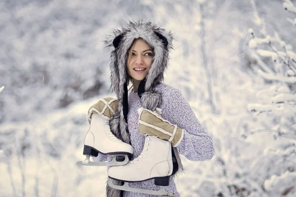 Жінка щаслива посмішка з фігурними ковзанами на деревах у снігу — стокове фото