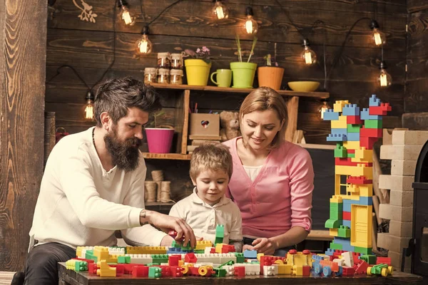 Familia feliz jugando con el constructor en casa. madre y padre ayudando a construir con ladrillos. —  Fotos de Stock