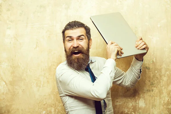 Hombre o hipster con barba larga mantenga portátil, exceso de trabajo —  Fotos de Stock