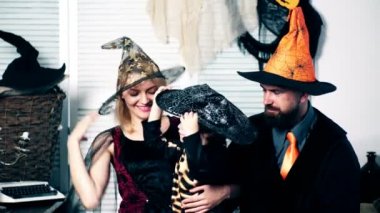 Anne ile baba ve oğullarının şapkalar ve Cadılar Bayramı takım elbise Cadılar Bayramı'nda iyi eğlenceler. Cadılar Bayramı partisi ve kutlama kavramı. Sihirbaz, cadı ve küçük iskelet Cadılar Bayramı'nda sarılma.