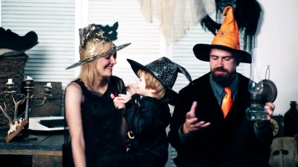 Mom, dad and their son are celebrating Halloween holiday. Family in costumes have fun on halloween. Halloween party and celebration concept. — Stock Video