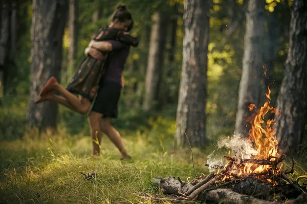 Fogueira chama na floresta com casal desfocado no abraço de amor — Fotografia de Stock