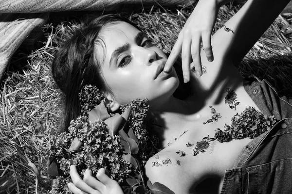 Bela mulher com buquê de flores lilás em um palheiro — Fotografia de Stock