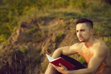 Kitap açık olan dalgın kaslı adam