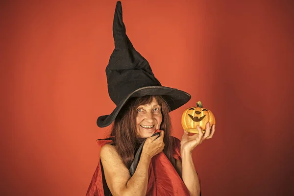 Mujer de Halloween sonriendo con calabaza sobre fondo rojo — Foto de Stock