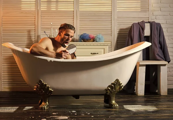 Musculoso hombre afeitando la barba en el baño —  Fotos de Stock