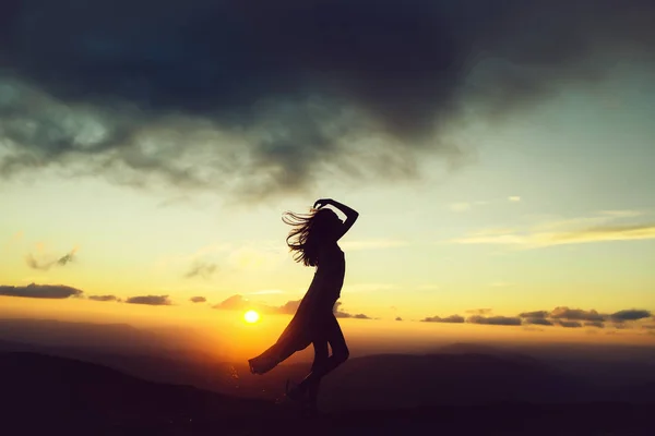 Mujer al atardecer o al amanecer en las montañas — Foto de Stock