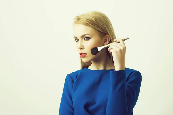 Makeup brush at blonde girl with red lips — Stock Photo, Image