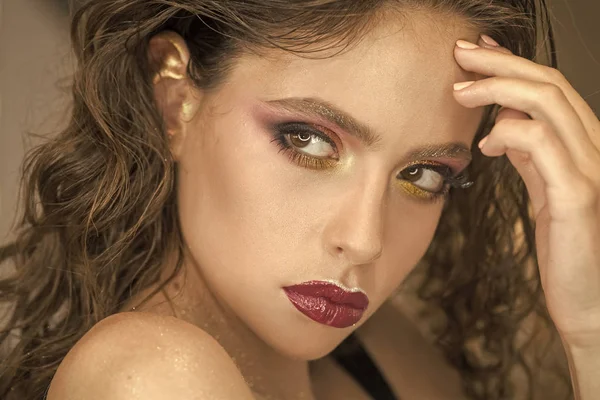 Woman with bright makeup and purple lips, beauty. Woman with young skin face, skincare. Beauty model with glamour look, makeup. Skincare, cosmetics and visage. Fashion girl with curly hair, hairstyle