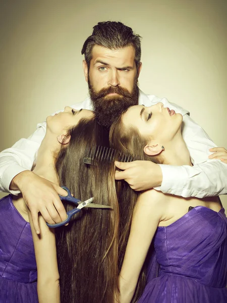 Homme barbu coiffeur et deux femmes — Photo