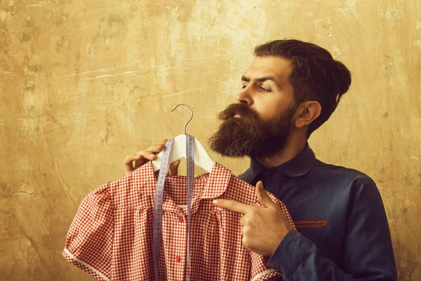 Uomo con barba tenuta vestito e metro a nastro in laboratorio su sfondo beige — Foto Stock