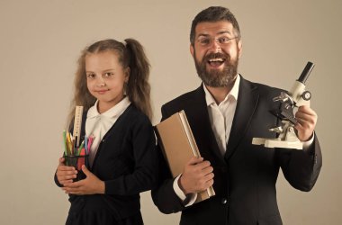 Çocuk ve baba kitap, kalem ve mikroskop tutun.