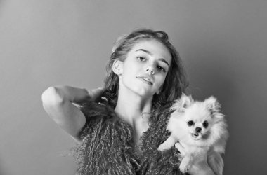 Spitz köpek kırmızı arka plan üzerinde gülümseyen kız elinde