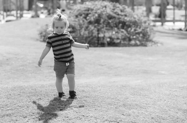 Yeşil çimenlerin üzerinde oynayan sevimli bebeğim