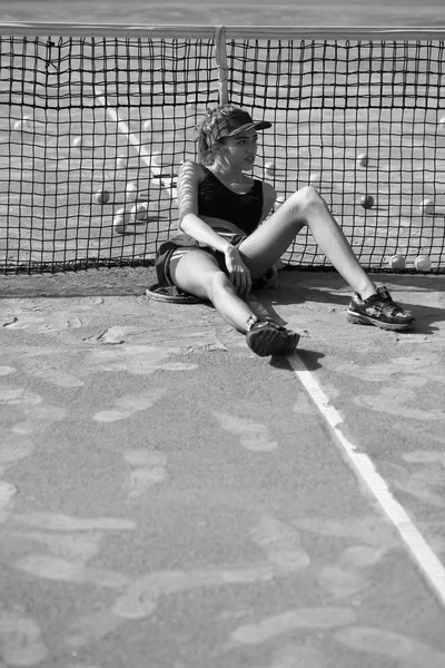 Mädchen sitzen und entspannen auf dem Tennisplatz — Stockfoto