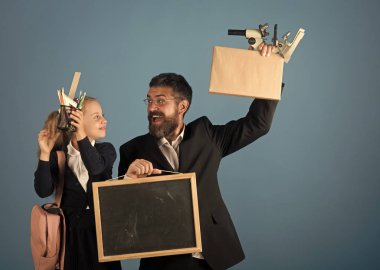 Çocuk ve öğretmen okul malzemeleri ve yazı tahtası tutun