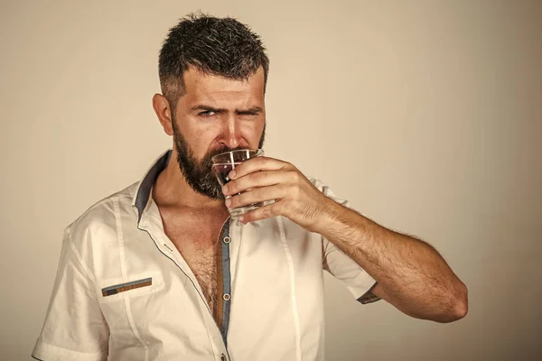 Man met lange baard houden waterglas op grijze achtergrond. — Stockfoto