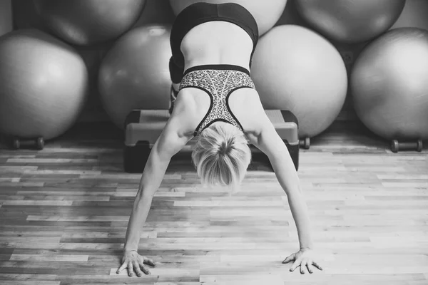 Sportlerin macht Handstand mit Beinen auf Stepper in Turnhalle — Stockfoto