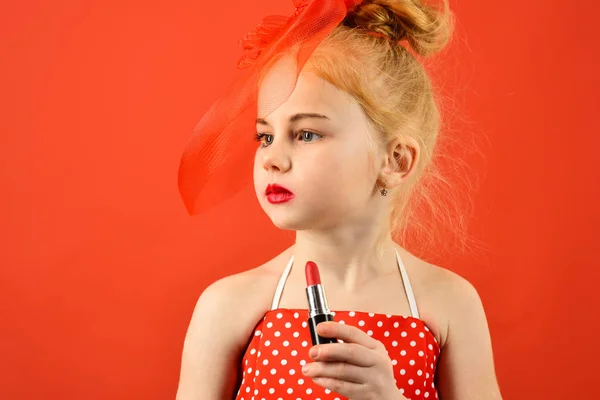 Retro girl fashion with cosmetics, beauty. Little girl hold lipstick and mirror. Fashion and beauty, pinup style, childhood. Child girl in stylish dress, makeup. Makeup retro look and hairdresser. — Stock Photo, Image