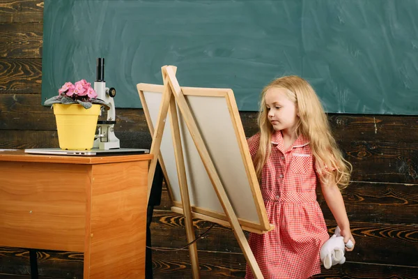 Quadro piccolo bambino pittura su cavalletto studio. Ragazza in studio di pittura — Foto Stock