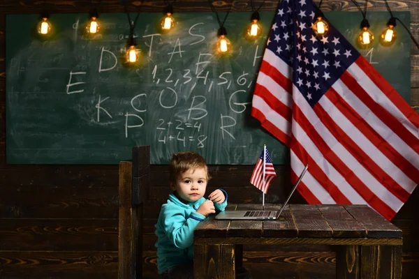 Schulkind beim Unterricht am 4. Juli. Kleiner Junge mit Laptop für Geschäfte unter amerikanischer Flagge. E-Learning oder Online-Kurse zu Hause. Patriotismus und Freiheit. Glücklicher Unabhängigkeitstag der USA — Stockfoto