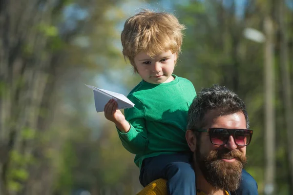 Father and son launch paper plane in park, dreaming concept. Little child dreaming about travelling by plane. Theres no better way to fly — Stock Photo, Image