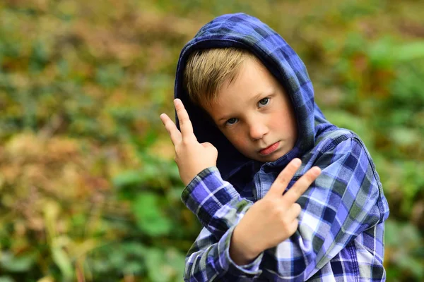 Casualmente fixe. Rapaz fixe. Menino pequeno com capuz casual. Uma criança pequena mostra um gesto insultuoso. Sou um pouco mauzão. A minha imagem é fixe. — Fotografia de Stock