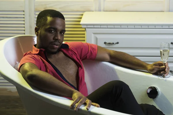 Macho con barba disfruta de la vida con copa de champaign en baño de lujo. Hombre con barba y bigote interior, fondo interior. Hombre en la cara relajada relajarse en la bañera. Vida de lujo concepto — Foto de Stock