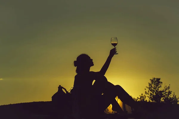 Silhouette eines Mädchens mit Wein — Stockfoto